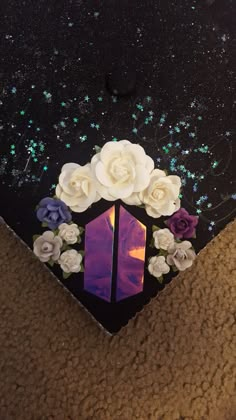 an upside down view of some flowers on a black surface with blue and white glitters