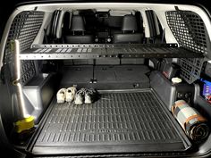 the back end of a van with its cargo compartment open and two pairs of shoes on the floor