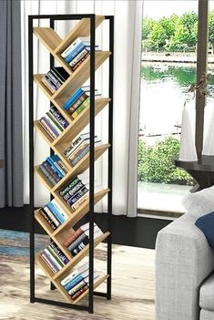 a living room with a couch and a book shelf in front of a large window