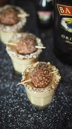 mini desserts are lined up on the counter with chocolate toppings and toothpicks