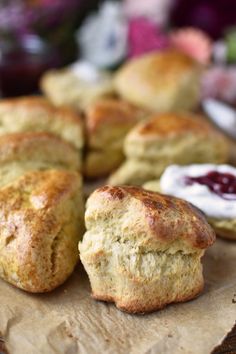 biscuits and jams on a table with flowers in the backgroufground