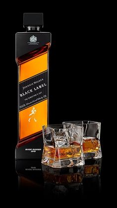 three glasses and bottle of whisky on a black background