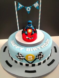 a blue birthday cake with a racing car on the front and number 5 on the back