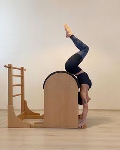 a woman standing on top of a wooden chair