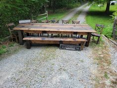 a wooden table and benches sitting on top of a gravel road