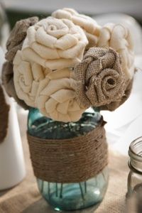 a vase filled with flowers sitting on top of a table covered in burlocks