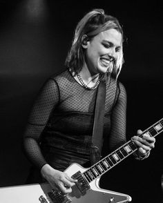 black and white photograph of a woman playing an electric guitar