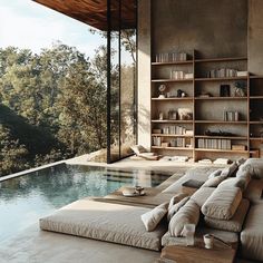 a couch sitting next to a swimming pool near a book shelf filled with lots of books