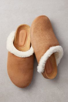 A classic clog with an extra-cozy touch—that's the Clara, your favorite new indoor/outdoor companion on chilly days and nights. Timelessly stylish and wonderfully comfy, these slip-ons are made from double-faced sheepskin, with plush shearling cradling the tops of your feet and a sueded finish on the outside. Keeping you supported from the ground up are cork footbeds that have been molded, contoured, and covered in suede. Rubber soles offer durability and traction so you can either scuff around Shearling Slip-on Clogs With Leather Footbed, Winter Sheepskin Slip-on Clogs, Casual Shearling Slip-on Slippers, Waterproof Suede Boots, Cozy Sheepskin Slip-on Slippers, Shearling Cushioned Slip-on Slippers, Suede Cowboy Boots, Comfy Flats, Clogs Style