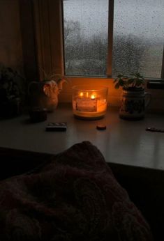 a candle sitting on top of a table next to a window