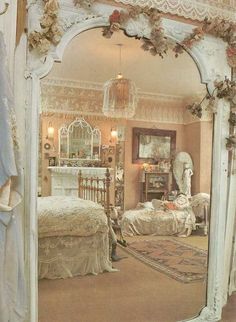 an ornate white mirror reflecting a bedroom scene