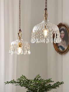 two glass chandeliers hanging from a ceiling