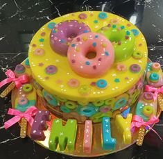 a birthday cake decorated with donuts and letters