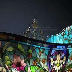 an ornate stained glass bathtub with flowers and leaves on the bottom, against a dark background