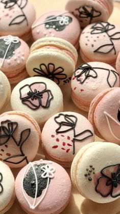 several decorated macaroons sitting on top of a plate with black and white designs