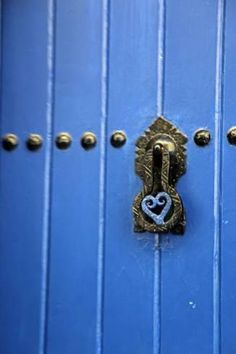 a blue door with a heart shaped lock on the front and side panel, which is painted gold