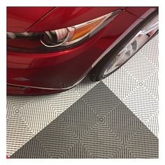 a red car parked in a garage with its hood up and the tail light on