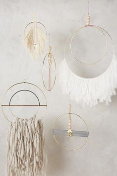 three circular wall hangings with tassels on them