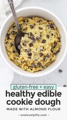 a bowl filled with cookies and chocolate chips next to a spoon on top of a table