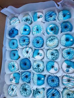 there are many blue and white donuts in the box