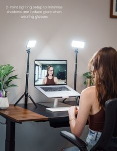 a woman sitting at a desk with a laptop on it and a video conference screen in front of her