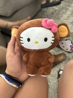 a person holding a hello kitty stuffed animal