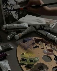 an artist's palette with paint and brushes on it