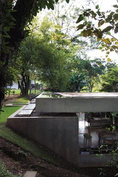 the concrete structure is surrounded by trees and greenery, with chairs on either side