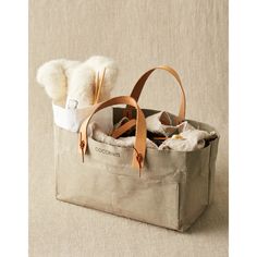 a tote bag filled with items sitting on top of a beige tablecloth covered floor