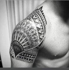 black and white photo of a man's arm with an intricate tattoo design on it