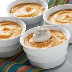 four white bowls filled with different types of dip