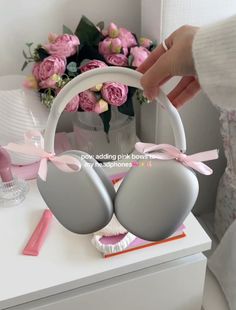 two bras with pink bows on them are sitting on a table next to flowers