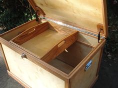 an open wooden box sitting on top of a sidewalk