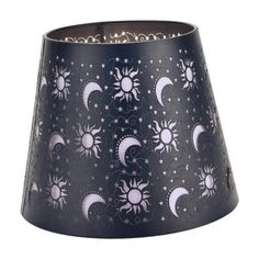 a black lamp shade with white stars and moon designs on it's bottom half