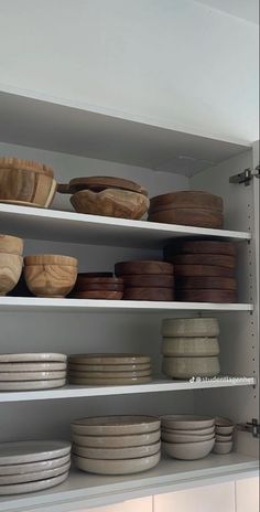 the shelves are filled with bowls and plates