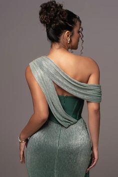 the back of a woman wearing a green evening gown with one shoulder draped over her shoulders