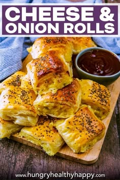 cheesy and onion rolls on a cutting board with dipping sauce in the background