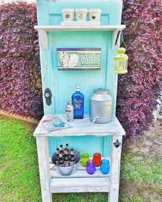 an old cabinet is painted blue and has bottles on the shelf, along with other items