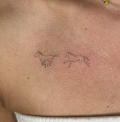 the back of a woman's shoulder with two horses drawn on it