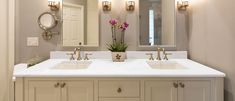 a bathroom with double sinks and two mirrors