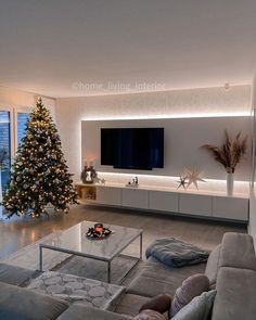 a living room filled with furniture and a christmas tree in front of a flat screen tv