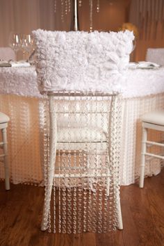 a table with white linens and chairs around it