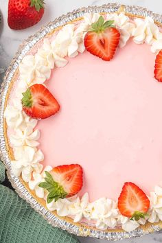 there is a pie with strawberries on it and whipped cream around the crusts