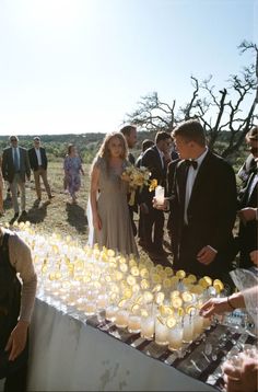 a group of people standing around a table filled with drinks