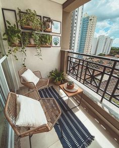 two wicker chairs sitting on top of a balcony next to a table and potted plants