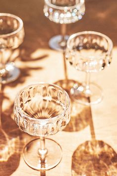 three wine glasses sitting on top of a table next to each other and one is empty