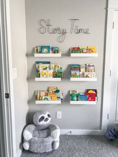 a stuffed animal sitting on the floor in front of a wall with shelves filled with books