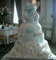 a large wedding cake sitting on top of a table in front of a chandelier