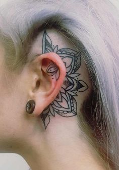 a woman's ear with a tattoo on it