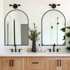 a bathroom with two mirrors and double sinks